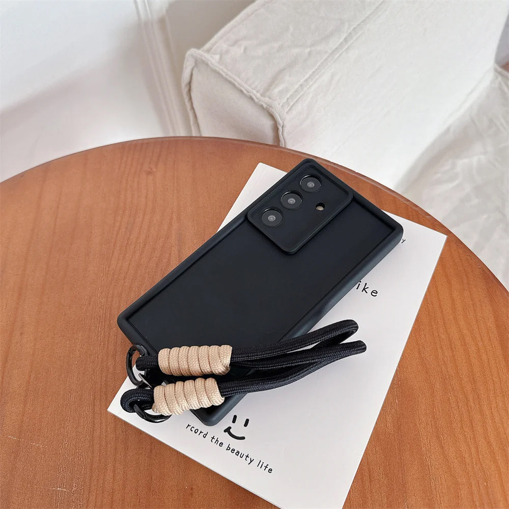 Black phone case with a lanyard on a wooden surface